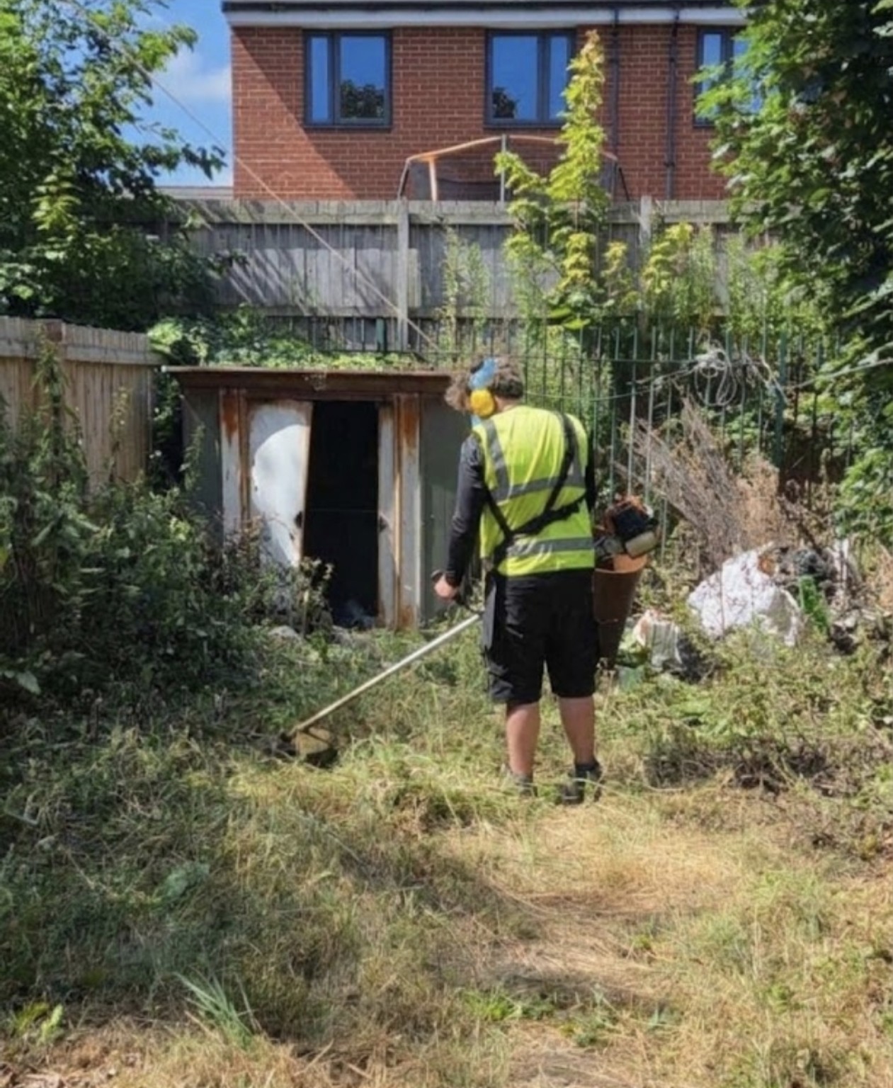 Fórsa clearing an overgrown garden with a strimmer